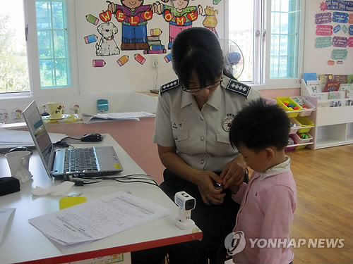 경찰관이 아이의 지문을 '실종아동 찾기 프로파일링 시스템'에 등록하고 있다.