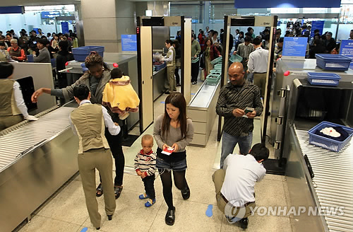 인천국제공항에서 탑승객들이 출국심사에 앞서 검색을 받고 있다. >