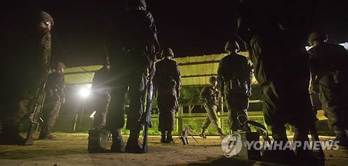 군 장병들이 야간 경계근무 군장을 점검하고 있다. >