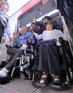 휠체어를 사용하는 장애인들이 지하철 시설 개선을 촉구하며 항의하고 있다.