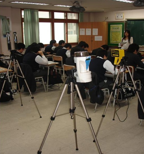석면이 함유된 건축자재로 지어진 학교 내에서 공부하고 있는 학생들. 공기 질을 측정하기 위해 포집기를 설치해놓았다.