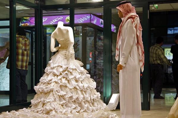사우디의 거리에서 웨딩드레스를 바라보고 있는 한 남성.
