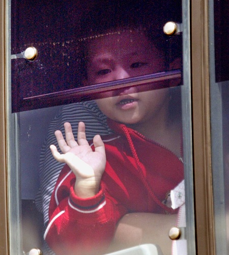 한국으로 입국하는 차량 안에서 밖을 내다보는 탈북자 소년.