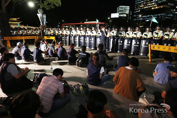 8일 저녁 민주노총이 광화문 정부 청사 앞에서 노사정위 야합 논의를 규탄하며 철야농성을 벌이는 가운데 경찰병력이 노동자들을 에워싸고 있다.